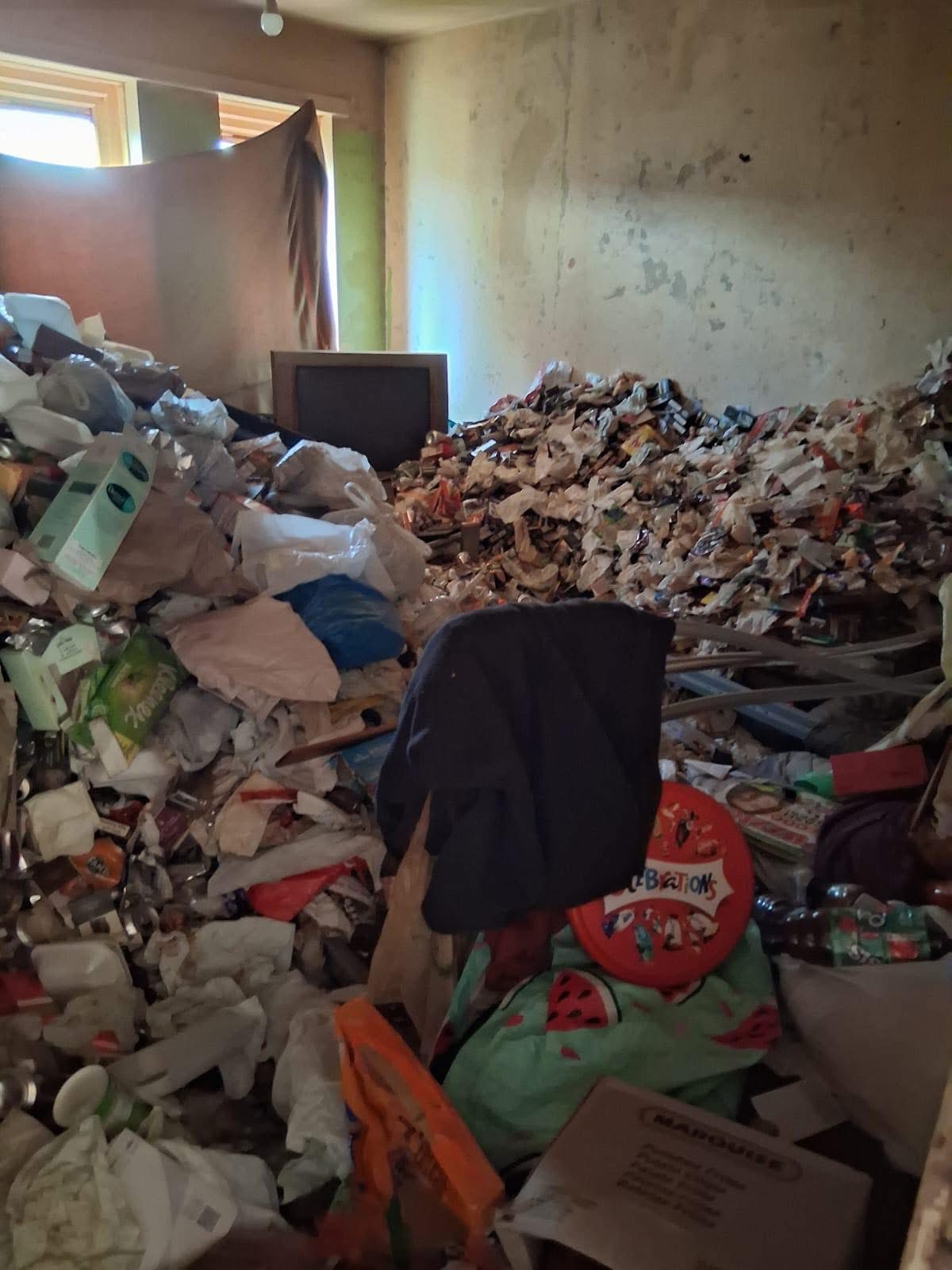 Hoarding clearance — extreme debris room, buried TV and waste piled to ceiling