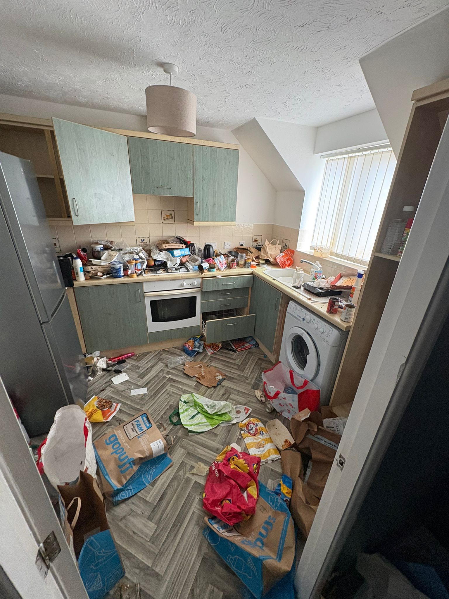 Hoarding clearance — kitchen buried under years of accumulated waste