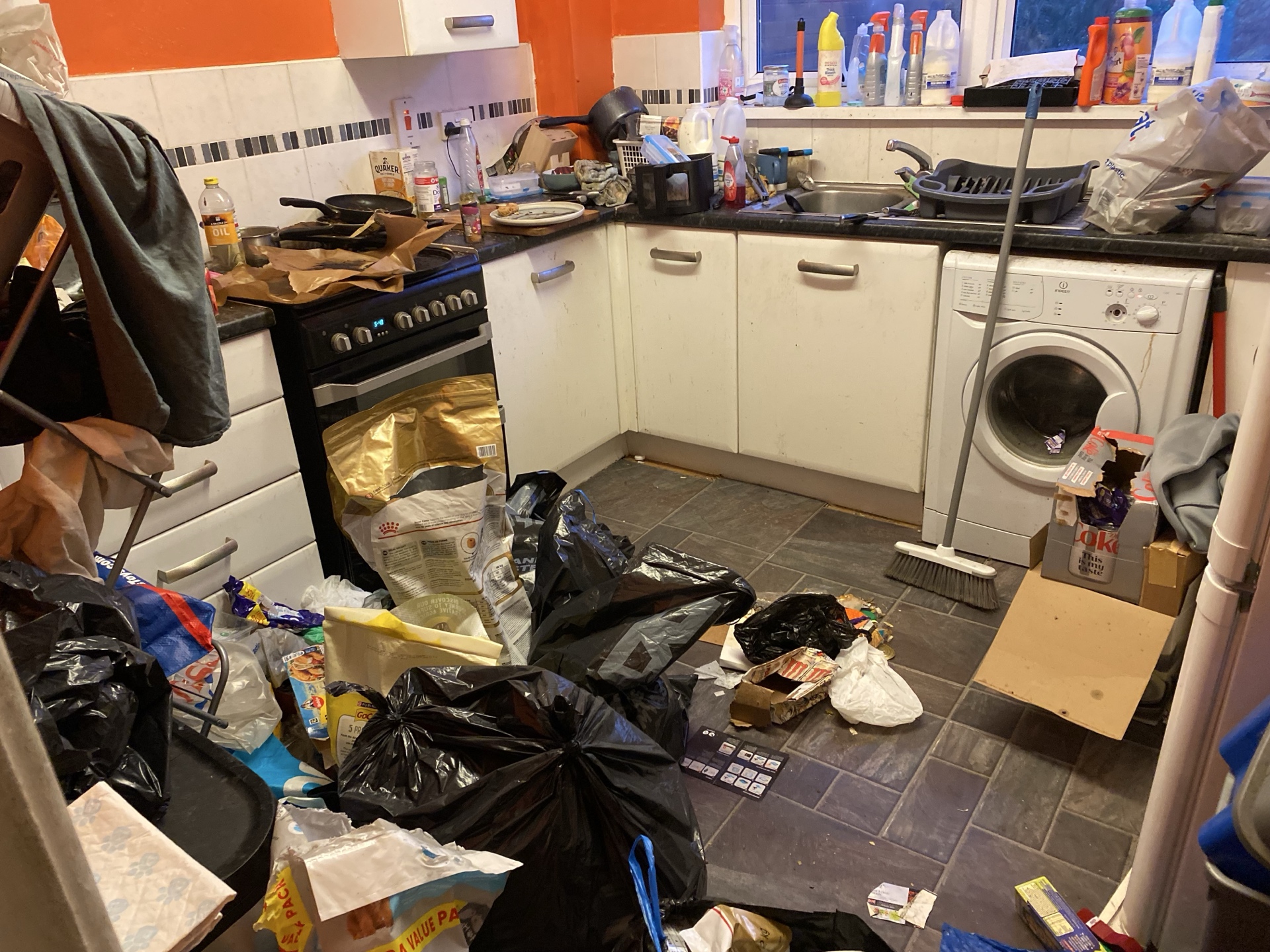 Hoarding clearance — contaminated kitchen with black bags and rotting waste